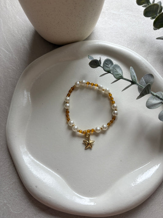 Perlenarmband mit weißen / braunen Perlen und einem Seestern - Charm