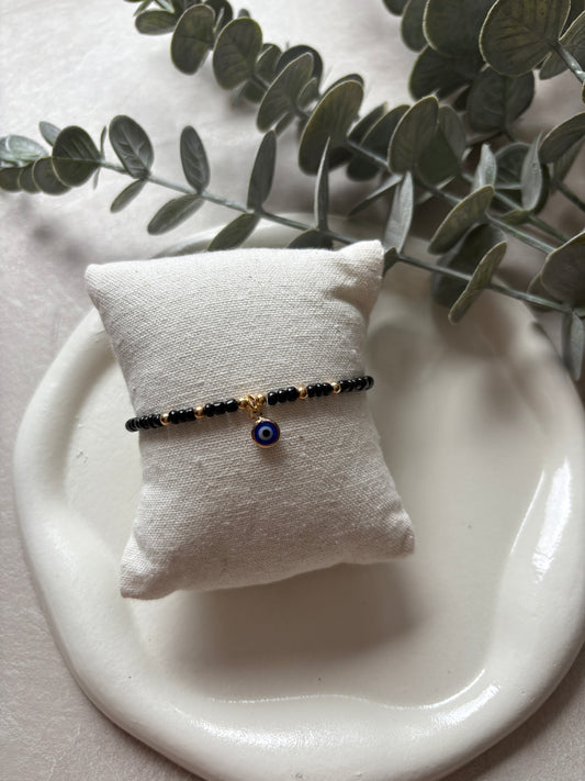 Perlenarmband mit schwarzen Perlen und Nazar - Charm