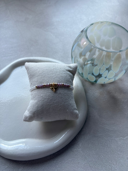 Perlenarmband mit weißen und lila Perlen und einem Bienen - Charm