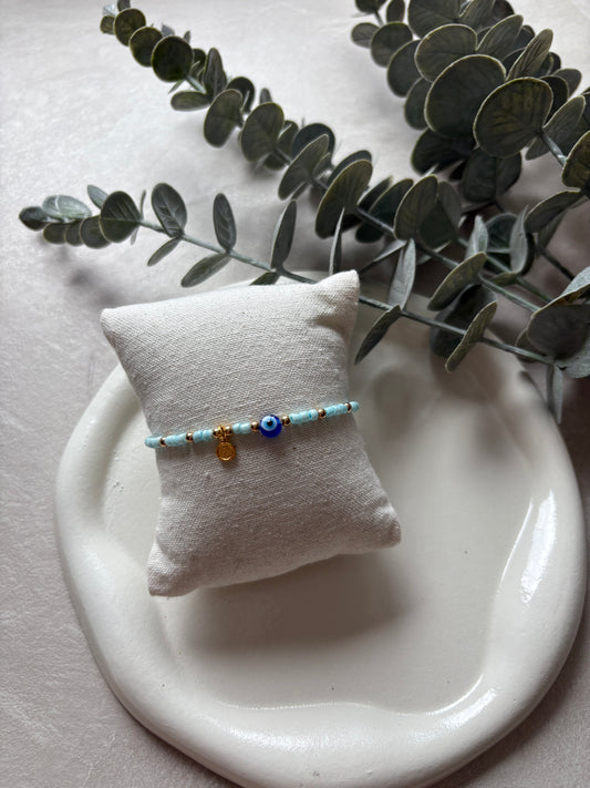 Perlenarmband mit blauen Perlen und einem Nazar / Plaketten - Charm